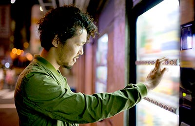 Man Looking at Vending Machine Items
