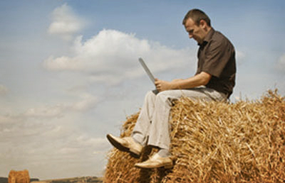 Man on Hay Bale With Laptop
