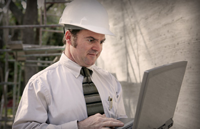 Construction Worker Looking at Laptop