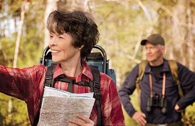 Senior Couple Taking Hike in Woods Looking at Map