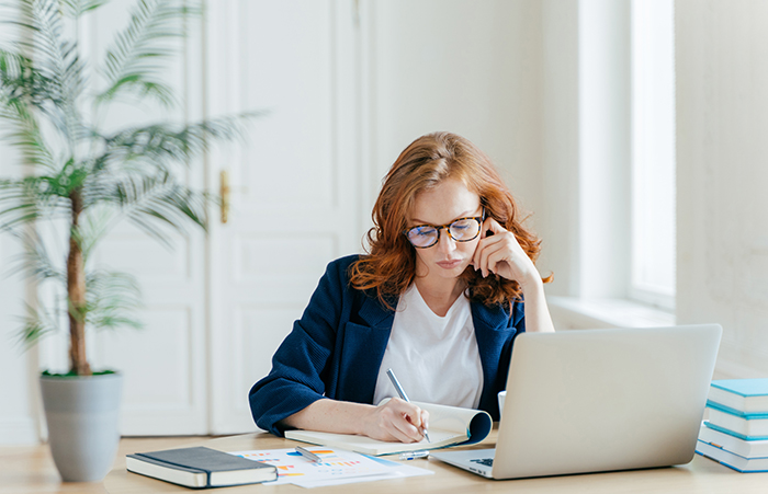 Woman at desk look at notepad