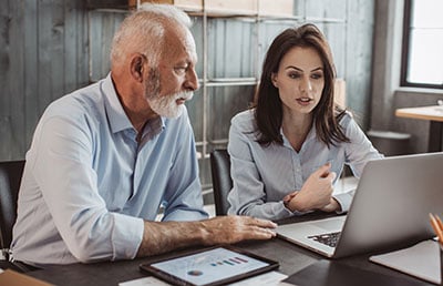 <img src=”businessexit.jpg” alt=”Man and Woman looking at laptop”>