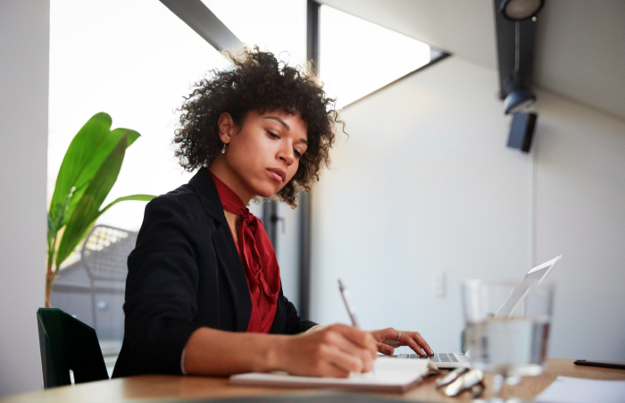 Female Advisor writing notes at desk