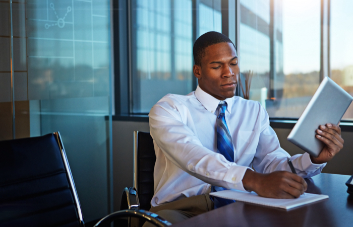 Business man writing report using tablet