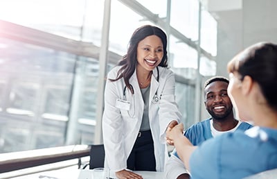 Doctor shaking hand with patient in hospital