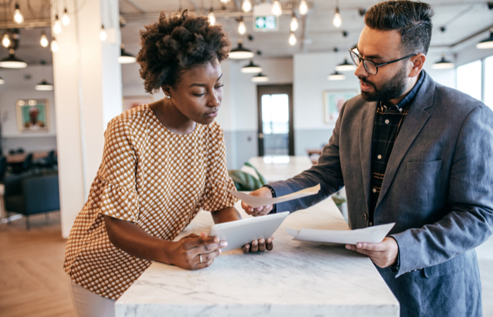 Two people discussing paperwork