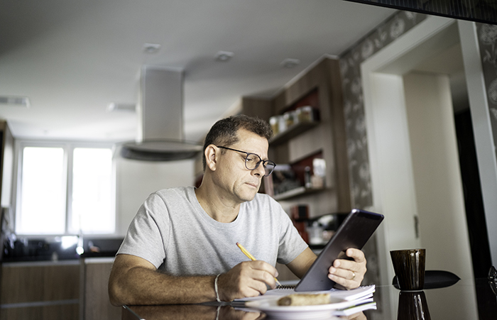 ManatHomeLookingatTablet