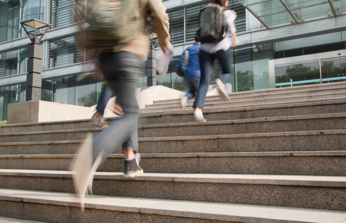 Students running up campus stairs