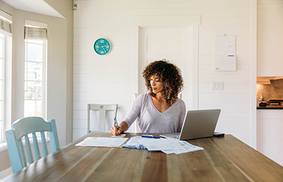 woman at kitchen table on computer