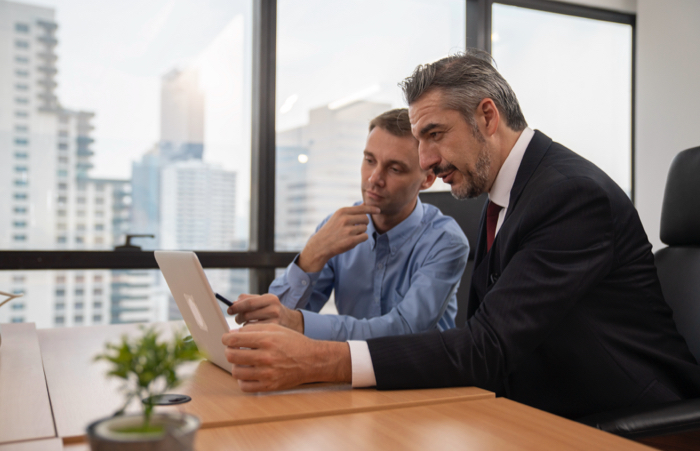 Business men looking at laptop in office