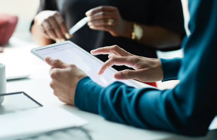 Close up of business person on tablet in meeting