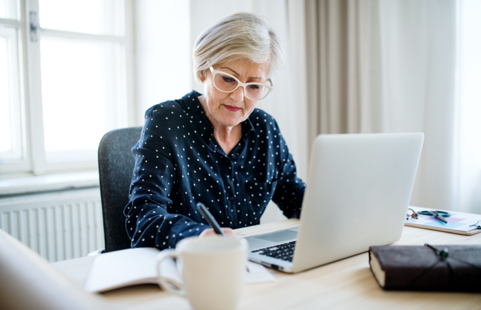 Senior woman with laptop working in home office