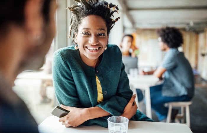 Woman smiling while speaking colleague