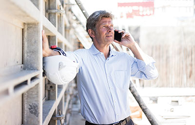 Man on Cell Phone on Construction Site