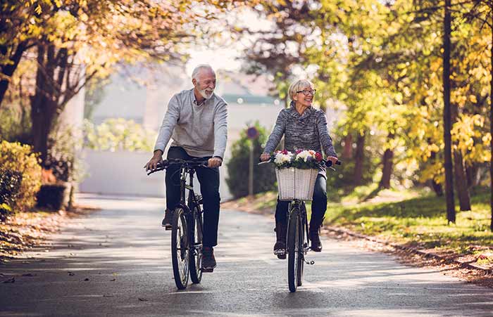 Couple Riding Bikes Down Neighborhood Street