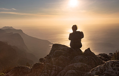 Back View of Woman Sitting on Rocks