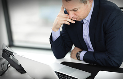 BusinessmanThinkingAtLaptop