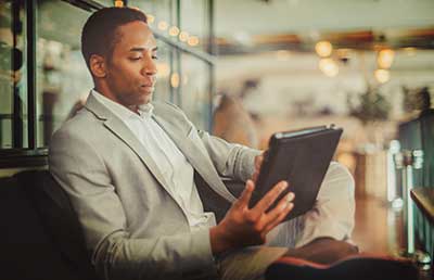 Businessman-Viewing-Tablet-while-Waiting