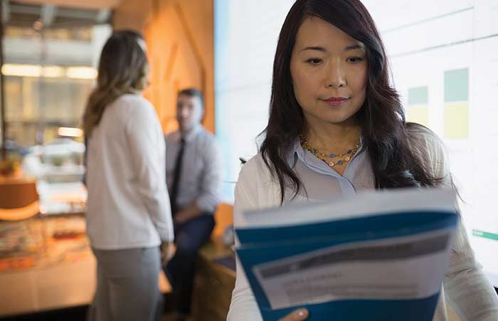 Businesswoman Reviewing Paperwork in Conference Room