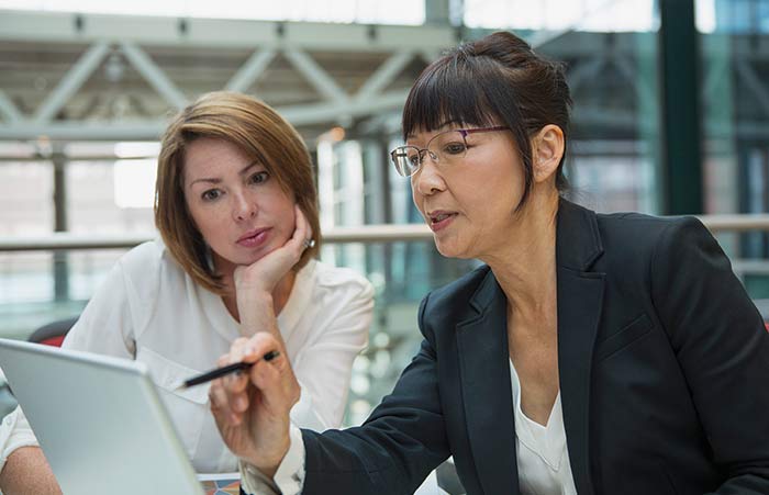 Businesswomen Using Laptop in Meeting