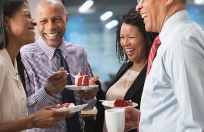 Four-Colleagues-Smiling-With-Cake