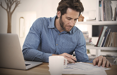 ManBeardDeskCoffeeCheckingNumbers