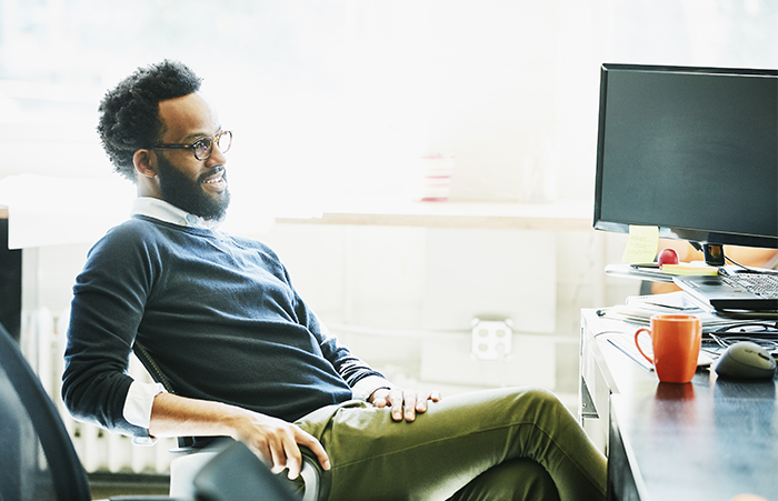 Smiling businessman seated at workstation in office