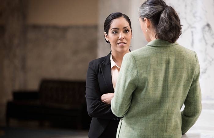 Two Women Discussion Granite Pillar