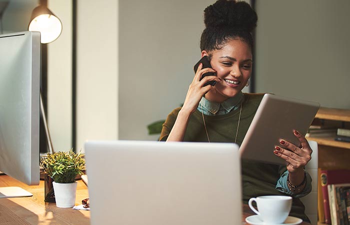 Woman Using Her Cellphone and Tablet in the Office
