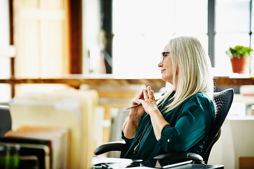 Woman In Office Room Thinking