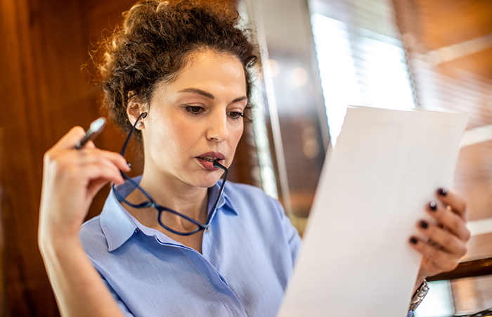Woman With Glasses Looking at Paper