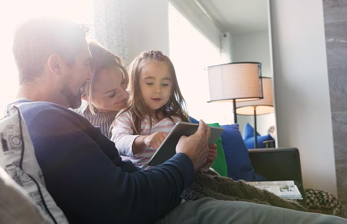 Family Looking at Tablet on Couch