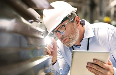 Manufacturer Checking Product with Flashlight