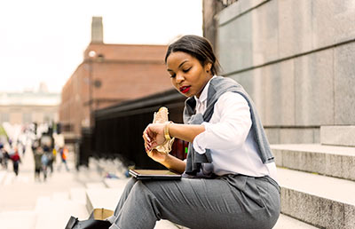 Older Student Checking Time Eating Lunch