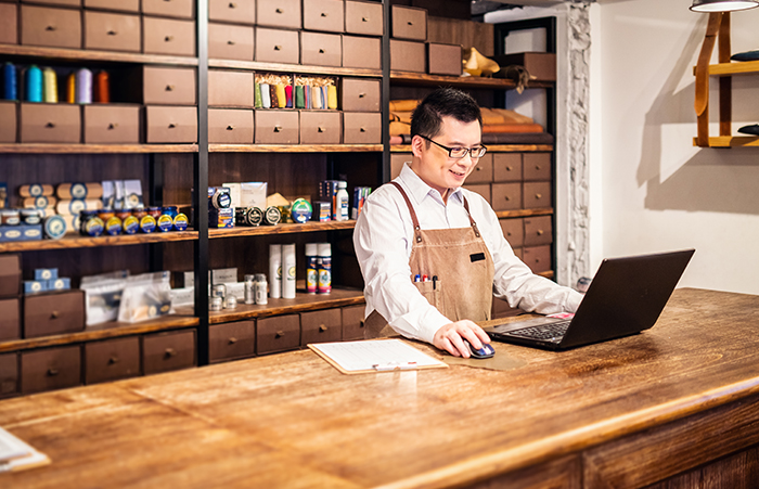 Shoe Shop Owner Working at Counter