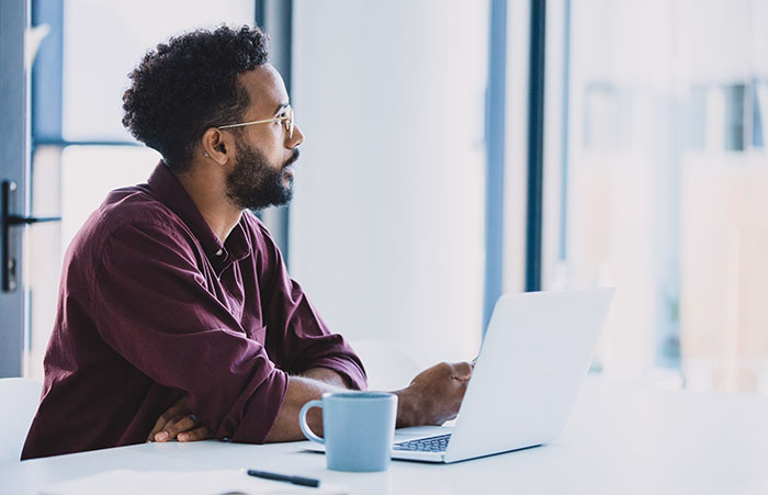 mansittingatdesklookingoutwindow
