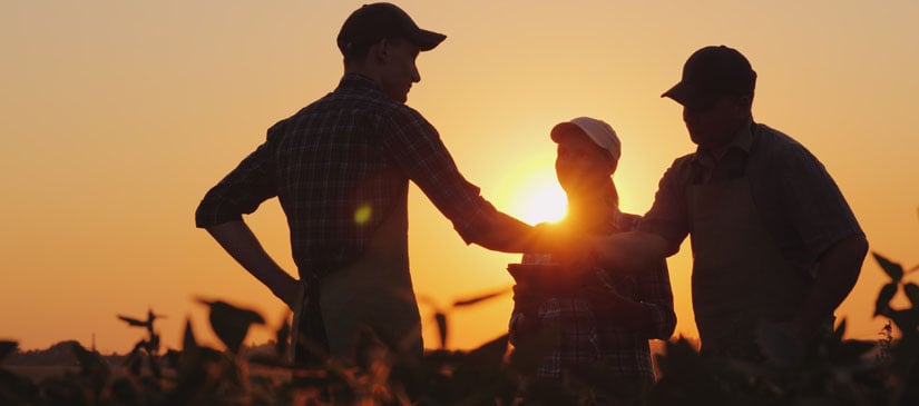 A group of farmers in the field, shaking hands
