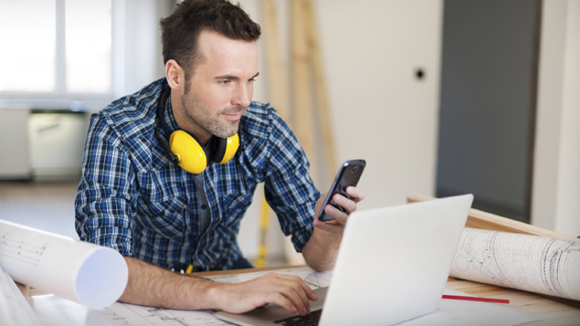 Contractor Planning Table Reading Smart Phone