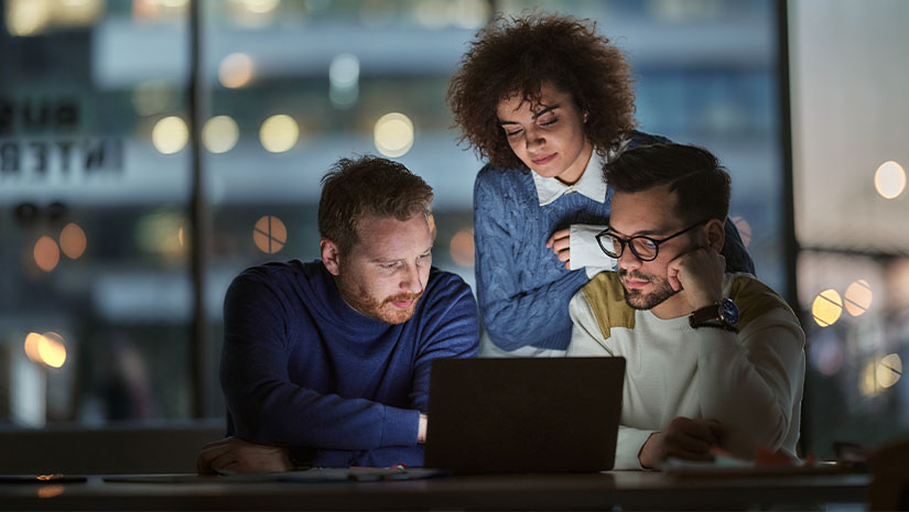 Business team working on a computer late in the day