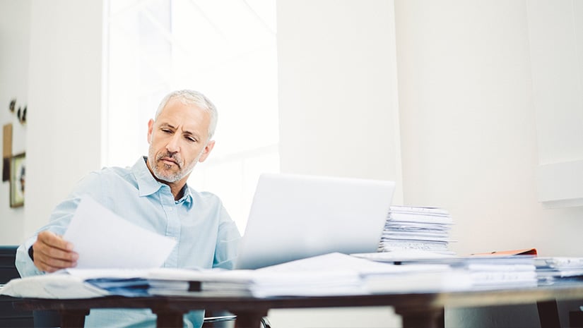Businessman reading document at desk in office