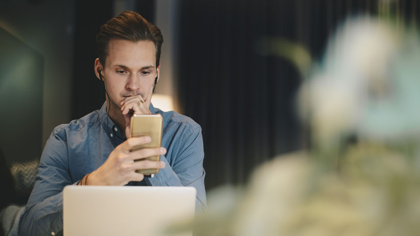 Businessman using smart phone at desk in office