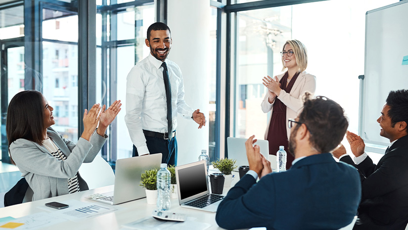 businesspeople applauding a colleague in an office