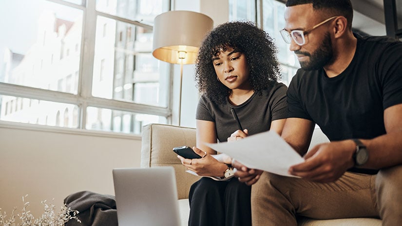 couple on sofa working on finances