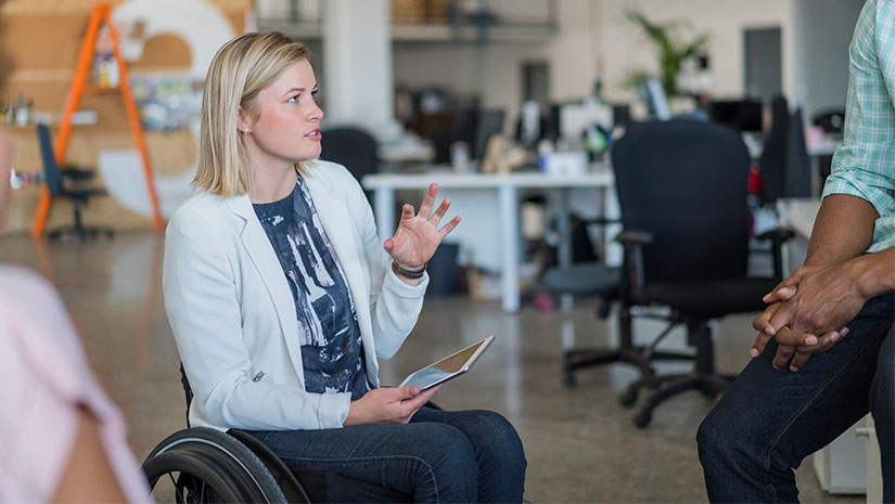 Disabled businesswoman discussing with colleagues