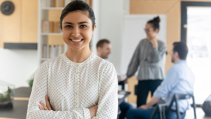 Head shot portrait smiling confident Indian businesswoman with arms crossed