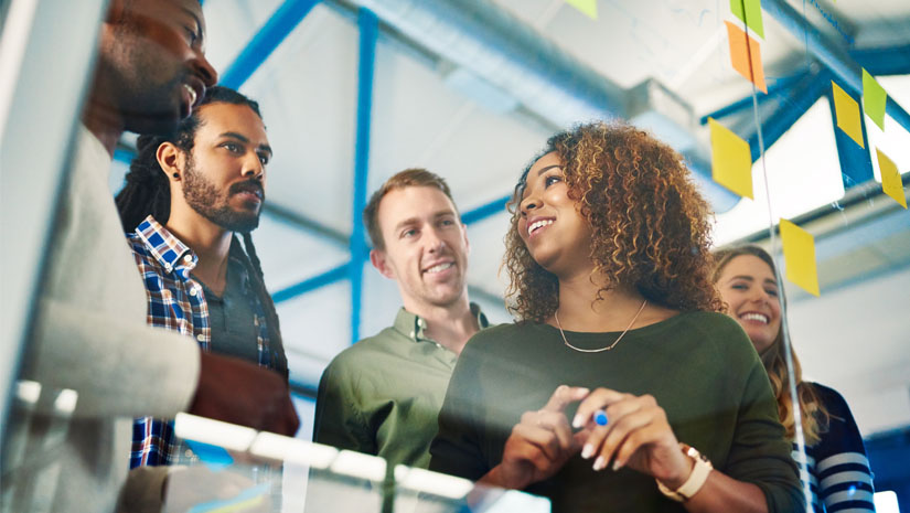 Shot of colleagues having a brainstorming session with sticky notes at work