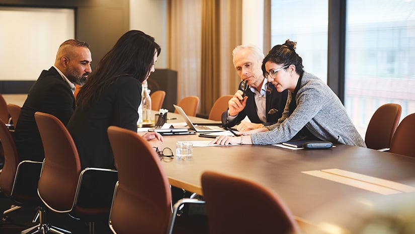 Male and female lawyers discussing document at conference table
