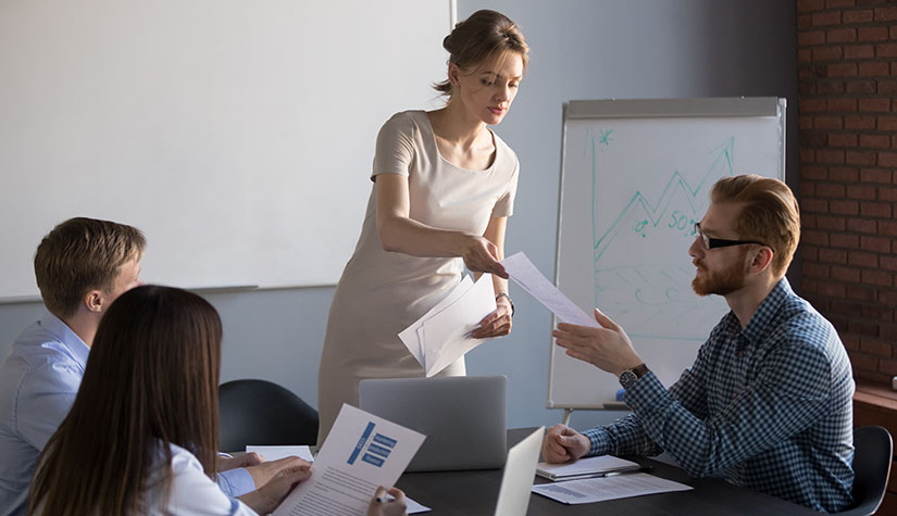Woman handing out materials during flipchart presentation