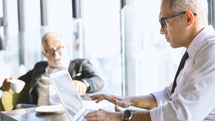 Portrait of Pensive mature businessman using laptop