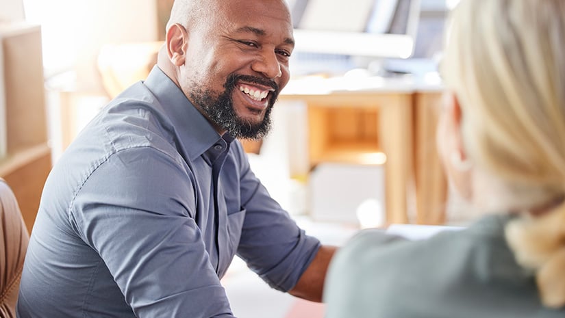 Shot of a businessman smiling while talking to a colleague